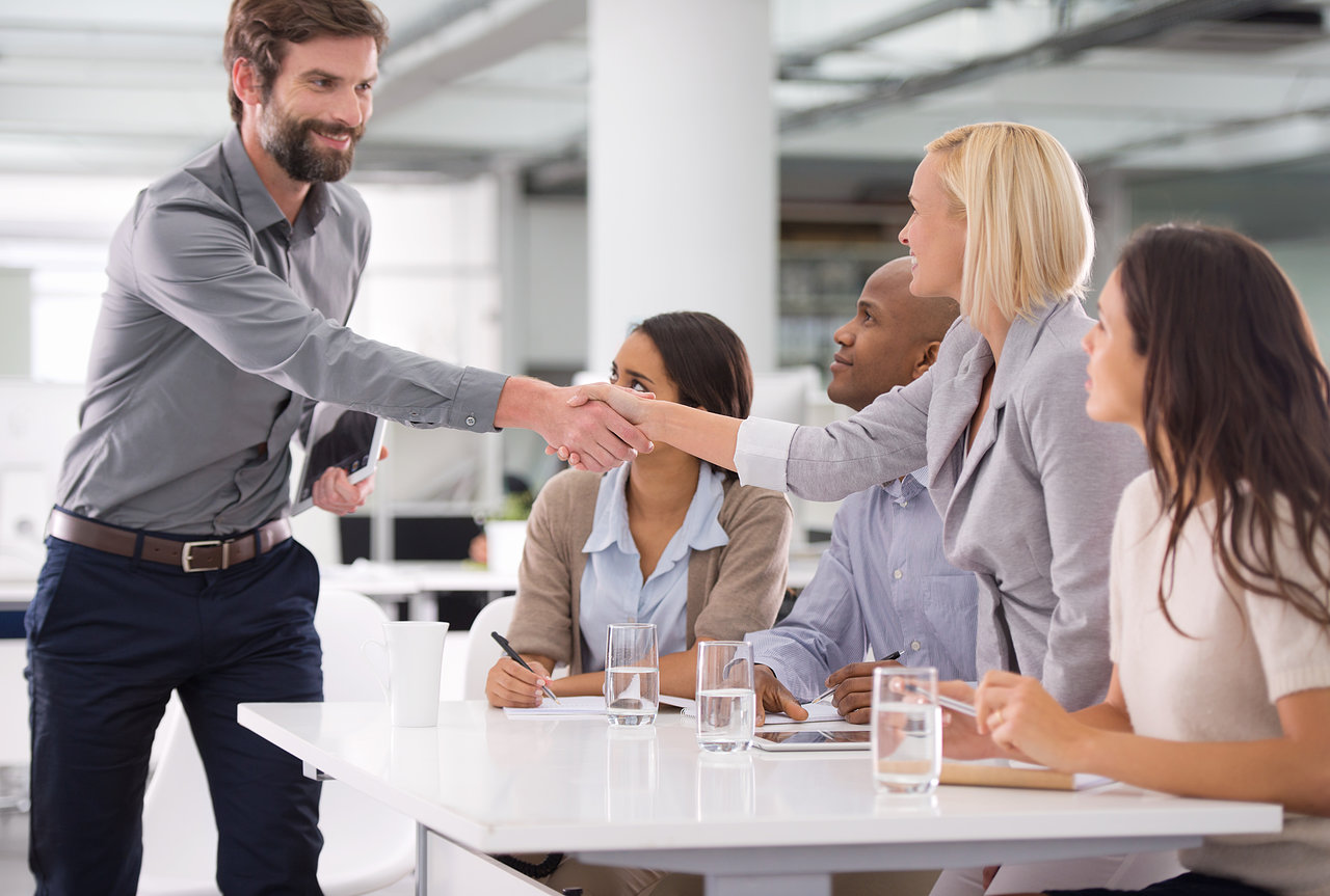 Shot of a businessman shaking the hands of his colleagues sitting on a panel